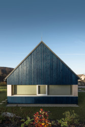 Chata v Jizerských horách, Markéta Cajthamlová, Architektonická projekční kancelář: Sokl domu je ze světlého pohledového betonu, fasáda pak z vertikálně kladeného prkenného obkladu v tmavě modré barvě