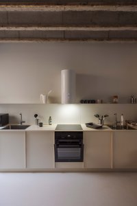 Kuchyně jsou zredukované jen na nezbytné minimum, důraz je kladen na společné prostory. (Metropol Be One Apartments v Bratislavě od BEEF ARCHITEKTI)
