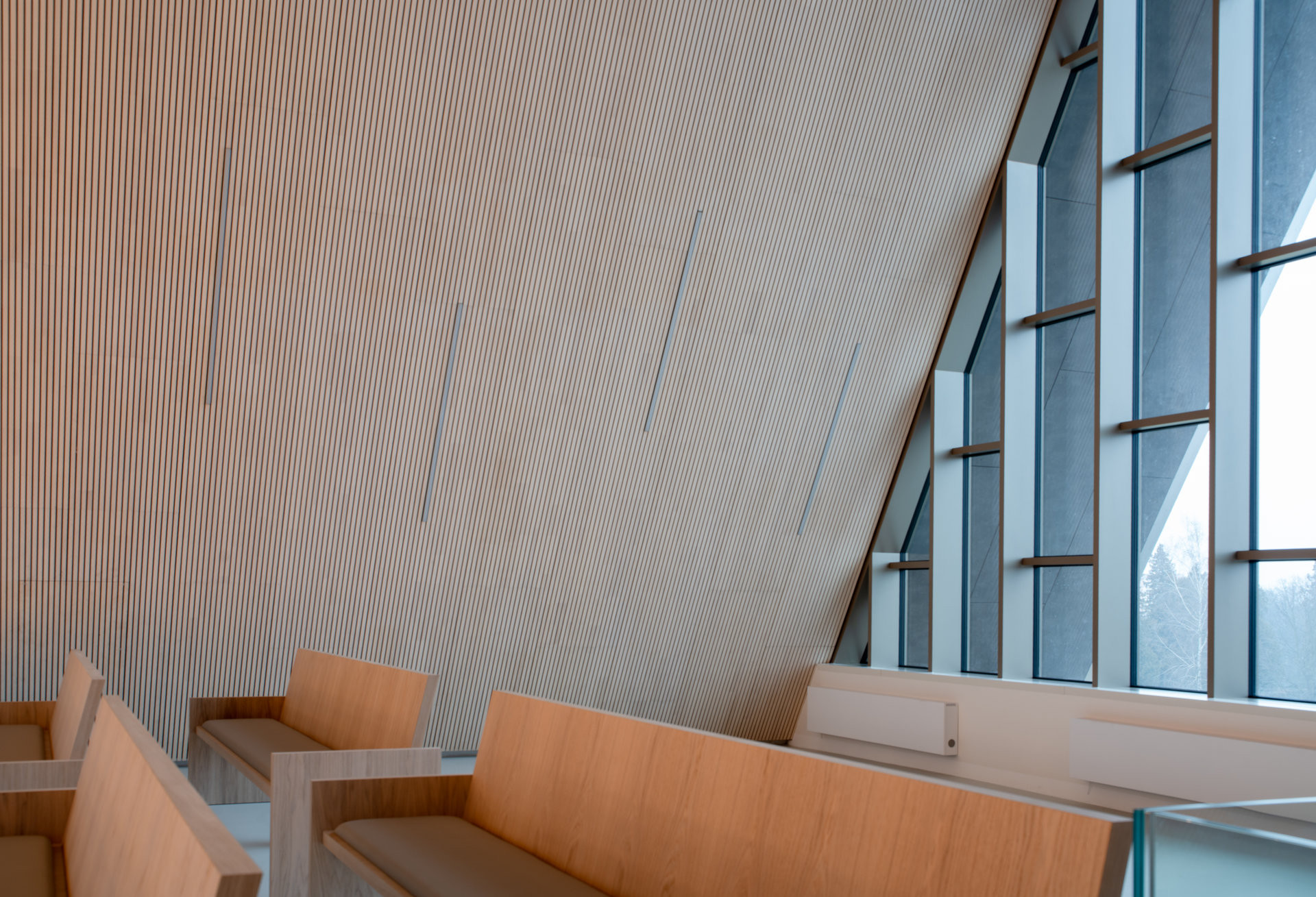 Interiér obřadní síně s akustickými panely Novatop - architektura obřadních síní na sebe nemá strhávat pozornost, ale zároveň musí vytvářet bezpečný prostor pro silné emoce.  (Rekonstrukce obřadní síně v Přerově; KT architekti)