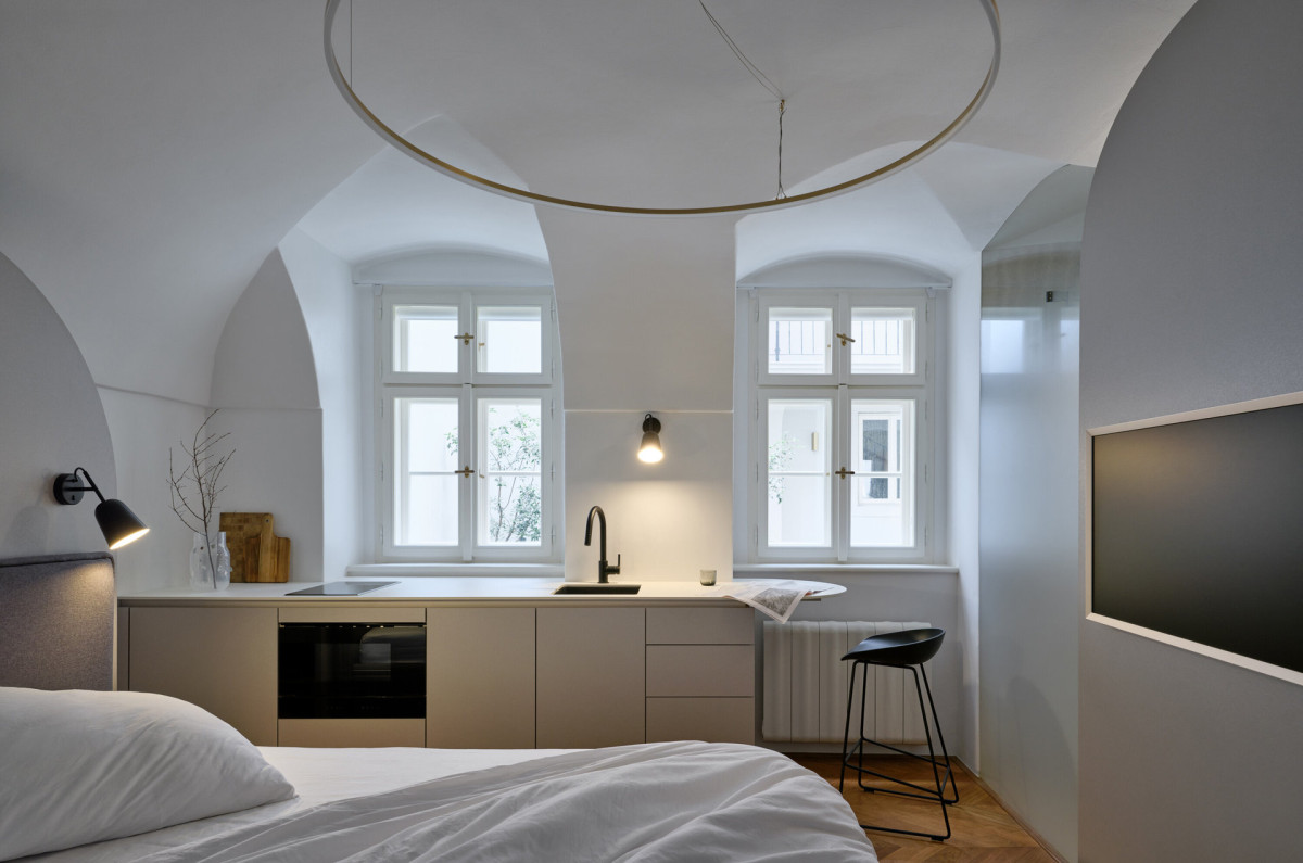 Součástí ubytování je poměrně velkorysá kuchyně s troubou i myčkou. (Rekonstrukce miniapartmánu; ateliér Tunicate)