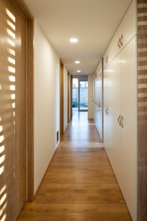 Chodba v soukromé části domu lemovaná sestavou vestavěných skříní (Dům na Hané; MOLO Architekti)