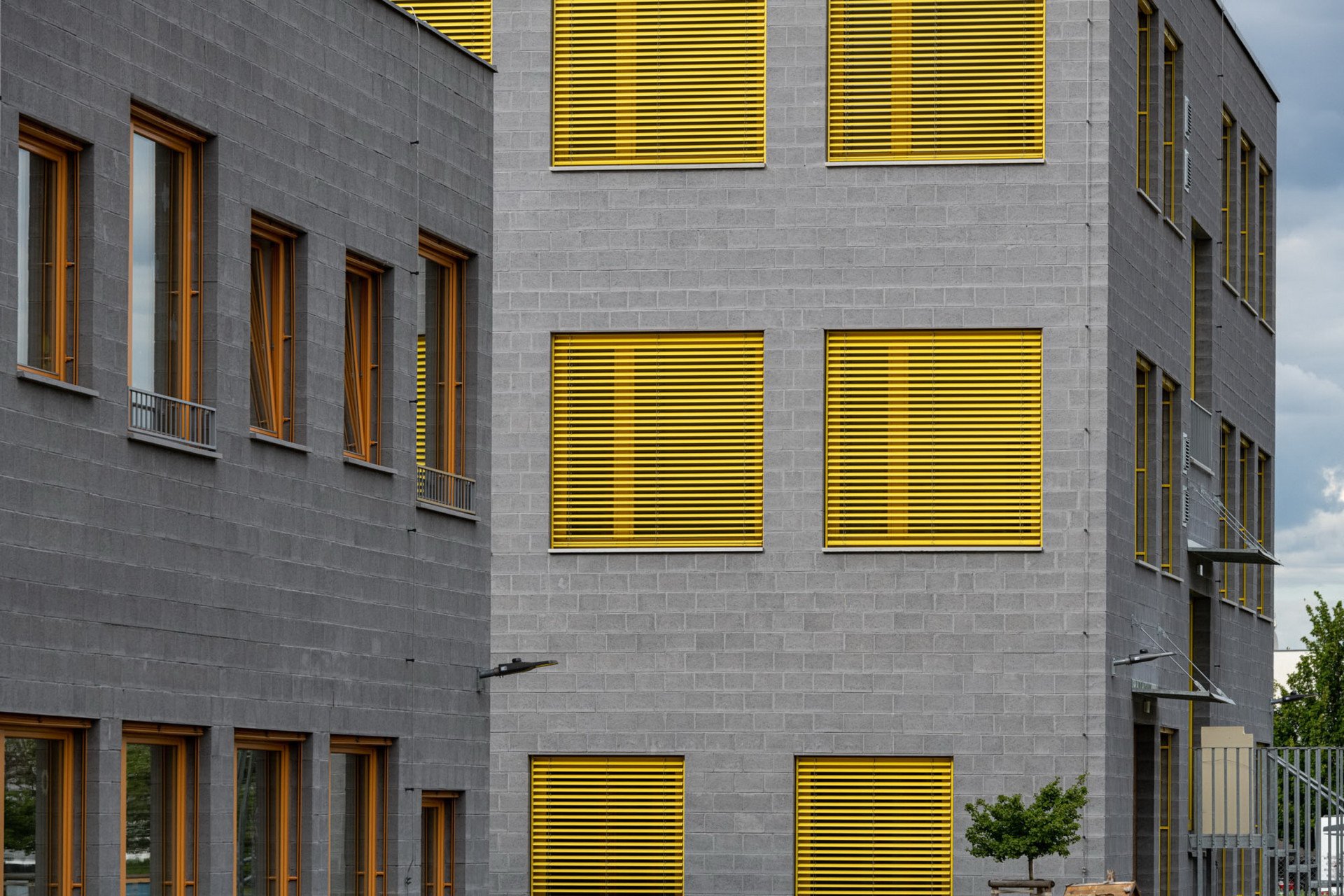 „Hlavním architektonickým principem návrhu je prostota a lapidárnost tvarového, materiálového i barevného řešení, bez zbytečných efektů. Vnější výraz celého souboru je solidní a pevný. Obě budovy jsou sjednocené čtvercovým půdorysem, přísným rastrem oken a jednotným stylem fasádního pláště,“ popisuje realizaci architekt Ondřej Tuček, podle jehož návrhu škola a školka vznikly.