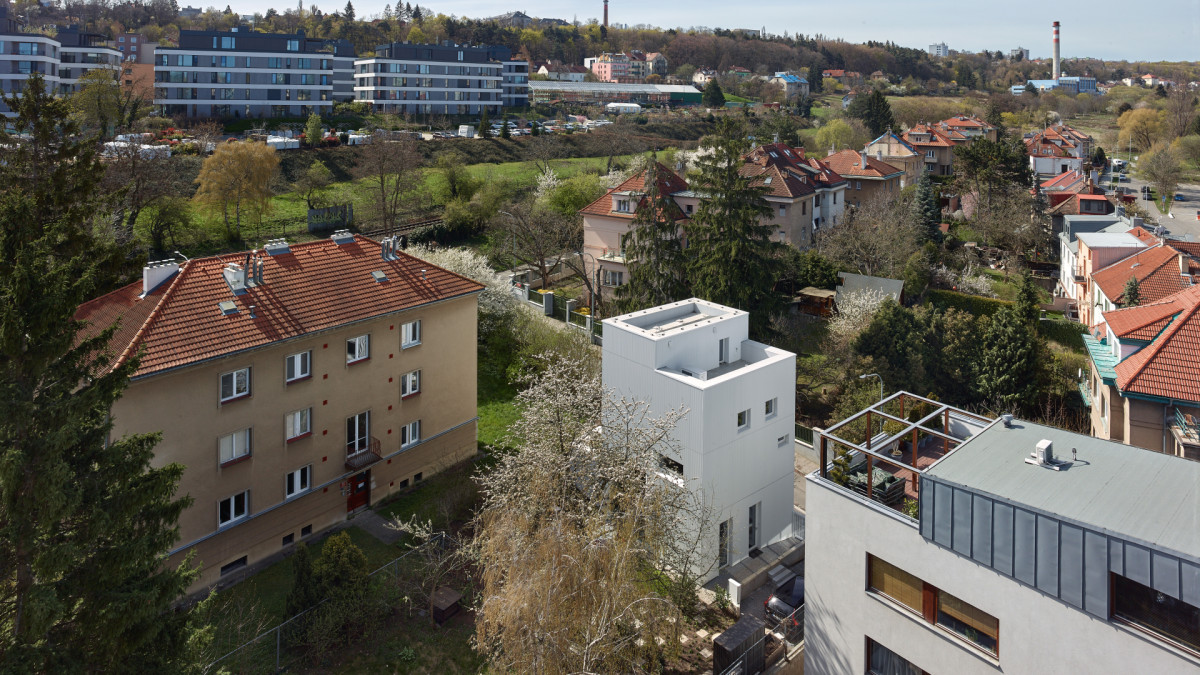 Dům vznikl v úzké proluce mezi drahou a dvěma bytovými domy. "Každý centimetr byl uvážlivým rozhodnutím," píší architekti. Vznikl dům bez chodby, s centrální jídelnou vysokou přes čtyři metry a třemi podlažími, která se navzájem posouvají o půl patra. Za návrhem stojí Stempel Tesař architekti.