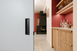 Posuvné dveře v interiéru zrekonstruovaného rodinného domu na pražském Žižkově jsou osazené mušlemi MINIMAL v povrchové úpravě titan černý mat