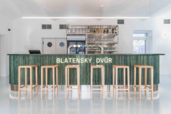 Výrazný je také bar obložený zeleně mořeným dřevem. (Interiér restaurace Blatenský dvůr, Dominik Cvrček)