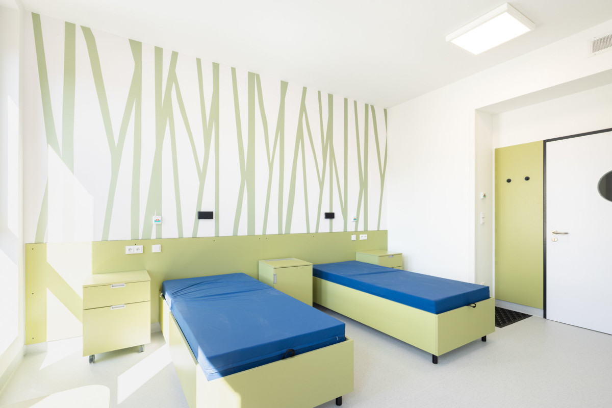 Pavilon obsahuje dvoulůžkové pokoje s vlastním sociálním zařízením (Pavilon psychiatrie v Ostrově od KOMA MODULAR; interiéry petit atelier)