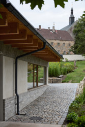 Stavba má betonový sokl, překlad, do výrazu se propisují ještě stropní trámy. (Krafferova zahrada v Jindřichově Hradci od matěj šebek architekti a Ateliér Za Mák)