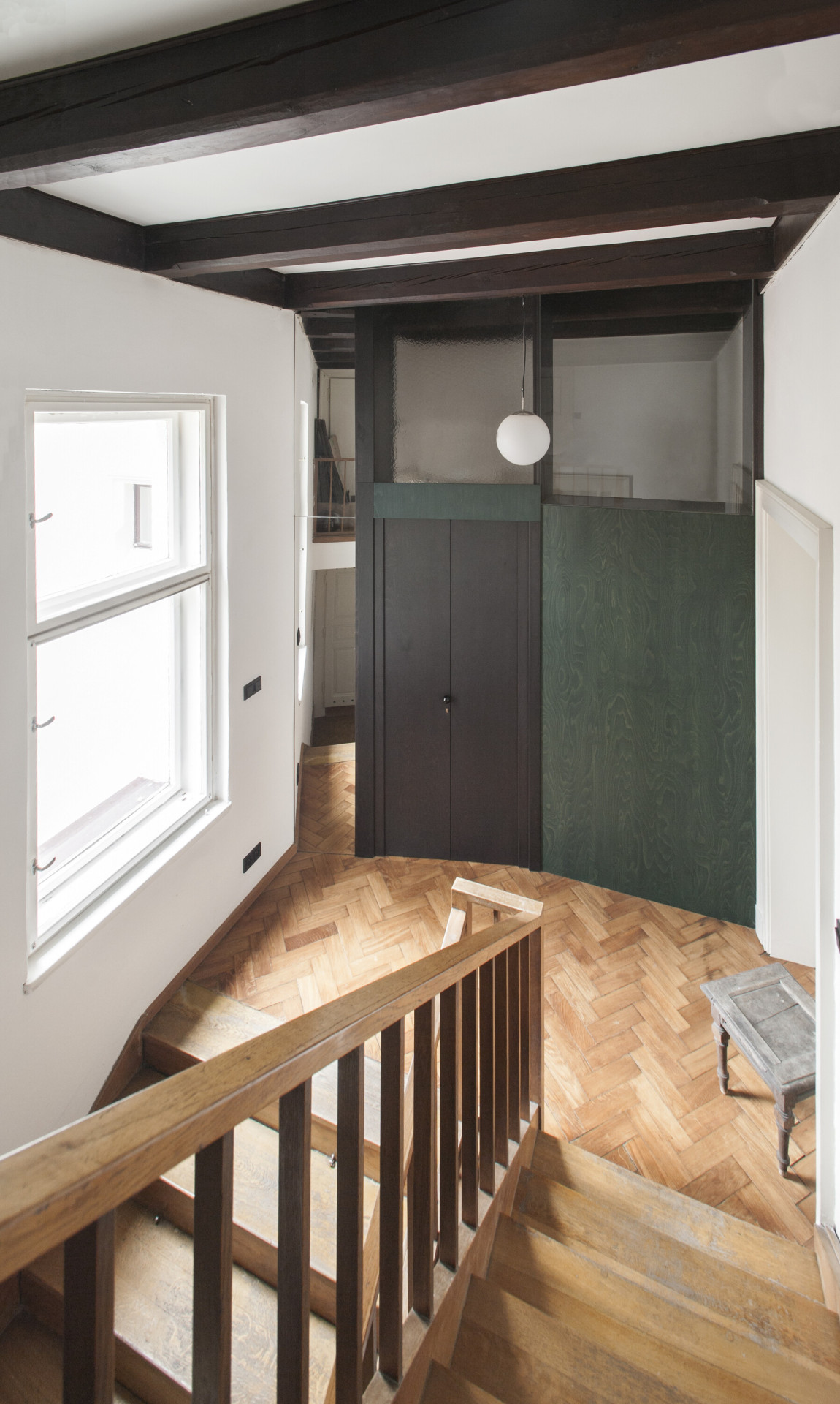 Rekonstrukce bytu v secesní vile, svobodová blaha - Geometrie dělící stěny je mírně zešikmená a natáčí zrcadlovou plochu do těžiště podesty