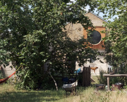 Statek stojí v divoké zelené zahradě. 