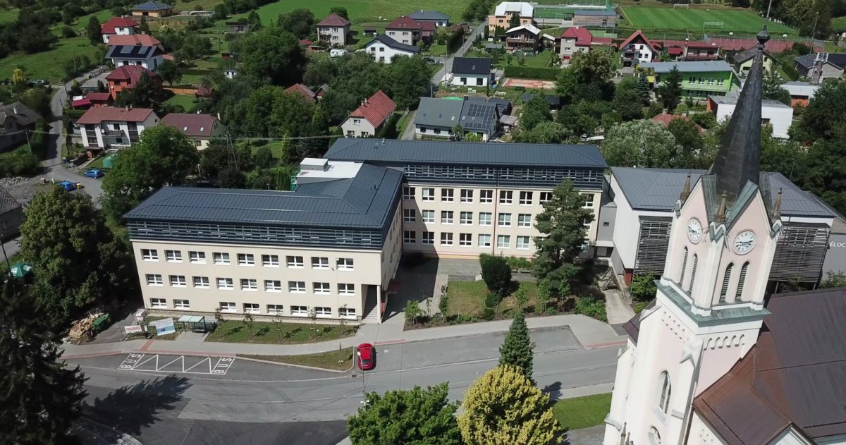 Nástavba základní školy Vidče vyřešila nedostatek prostor pro výuku. Pracuje s kontrastem mezi tmavou současnou vrstvou a původní světlou fasádou z 80. let.