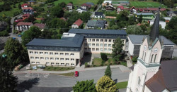 Nástavba základní školy Vidče vyřešila nedostatek prostor pro výuku. Pracuje s kontrastem mezi tmavou současnou vrstvou a původní světlou fasádou z 80. let.