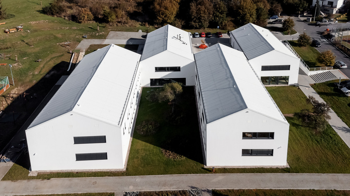 Architekti zařízení hmotově rozdělili do čtyř podlouhlých domů. (Dětská léčebna se speleoterapií v Ostrově u Macochy; Adam Rujbr Architects)