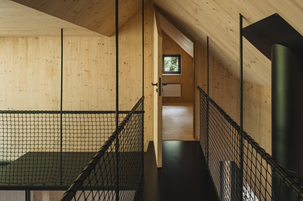 Kovová lávka propojuje horní pokoje. (Chata u Sázavy mezi skálou a řekou; Mimosa Architekti)