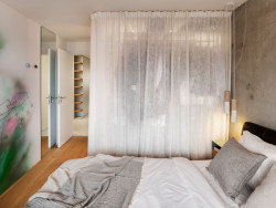 Závěs v ložnici odděluje nově vytvořenou šatnu od postele. (Byt U vodopádu, Iva Hájková Studio)