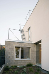 Členové rodiny se dostanou na střešní vyhlídku po pozinkovaném ocelovém schodišti, které vede podél severní fasády ze střechy jednopodlažního přístavku. (Rodinný dům v Radotíně, Papundekl architekti)