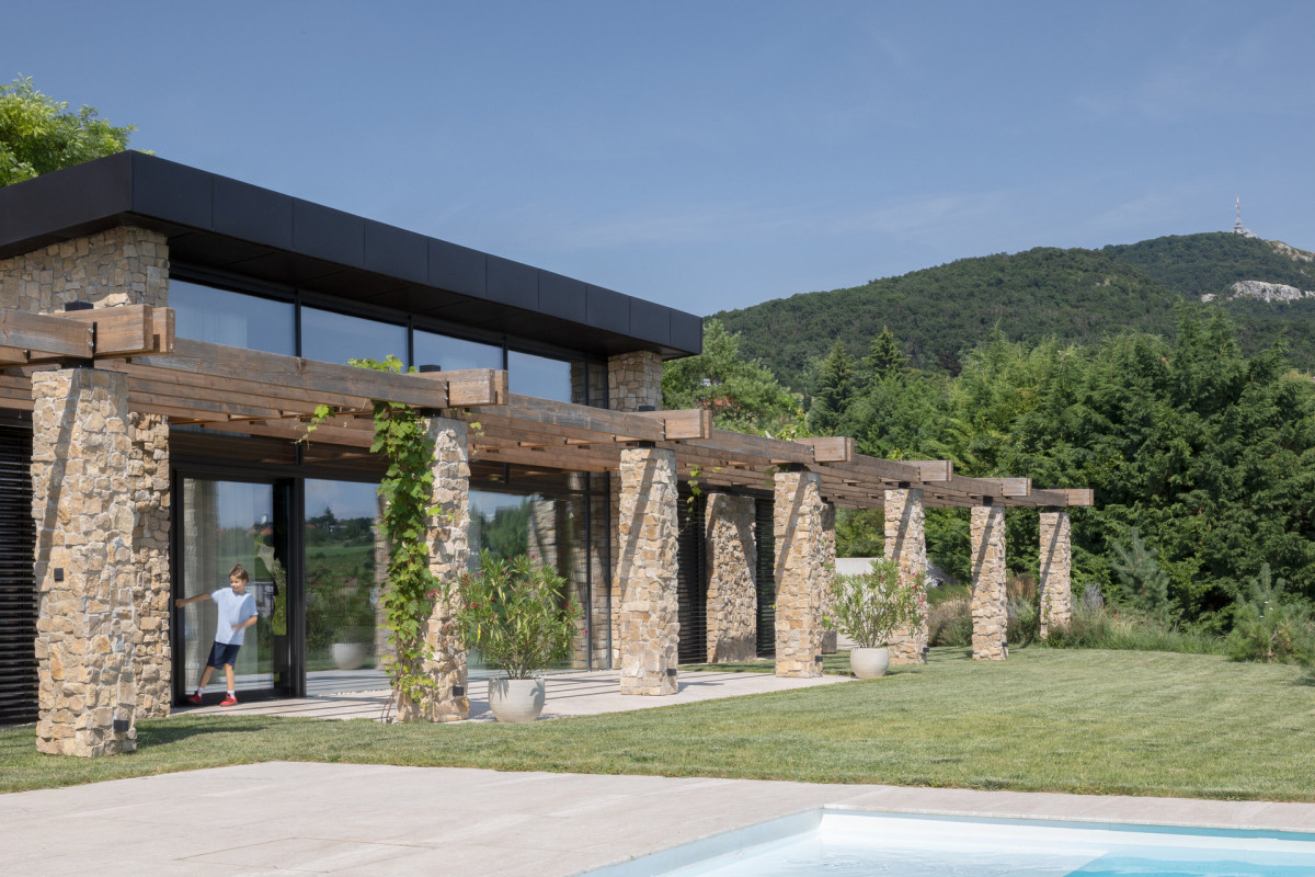 Význam obývacího pokoje podtrhuje zvýšený strop. Navenek se to projevuje střešním pavilonem umístěným ve středu domu. (Villa VICUS v Nitře; sebastian nagy architects)