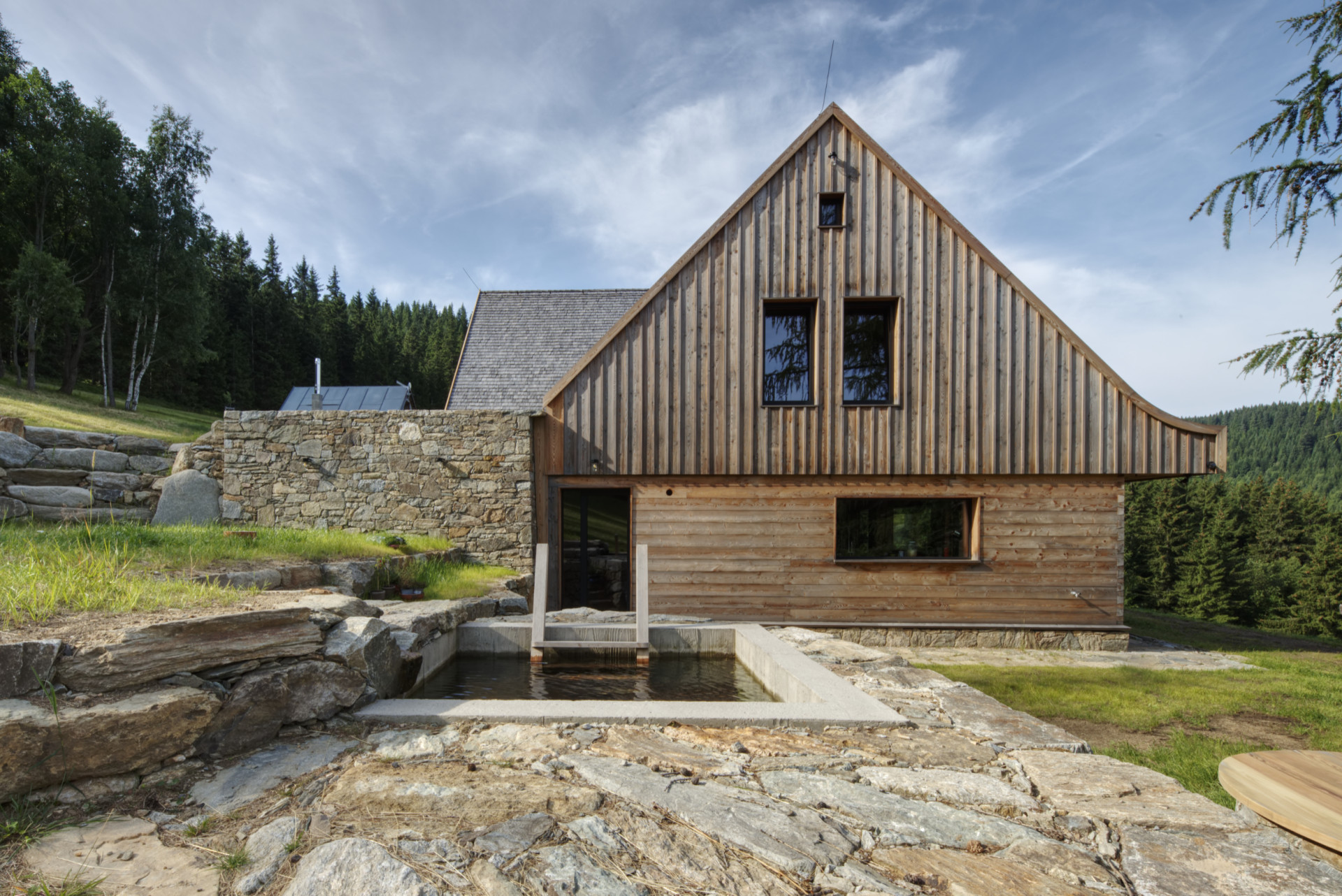 Je tu i bazén. Nebo spíš tůňka? Teplotu má  prý horskou. (Chalupa Wunderbaude, A1Architects)