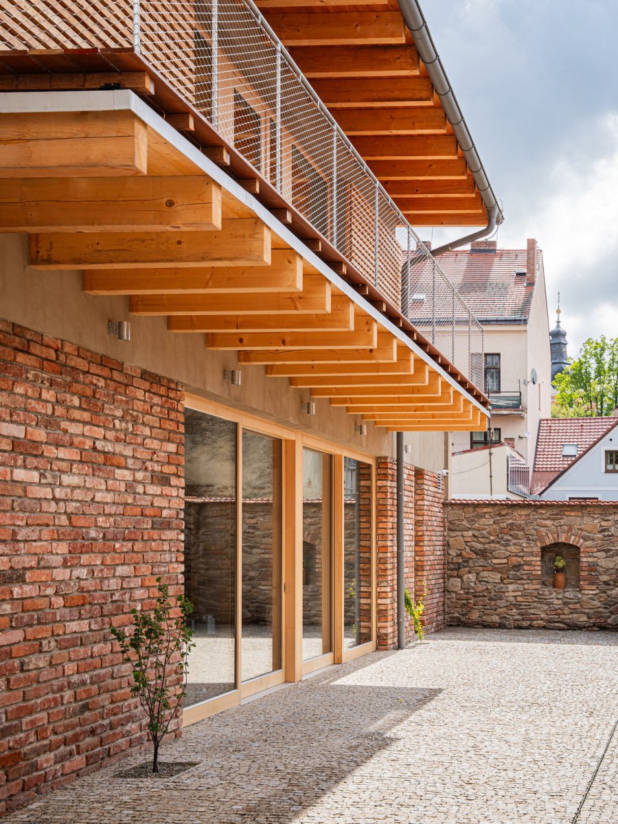 Nová přístavba využívá tradiční materiály, napříkald cihly z "bouračky."