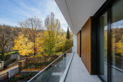 Pohled z balkónu v druhém obytném patře domu s ložnicí a dětskými pokoji (Block House v Šáreckém údolí v Praze; Studio MA)