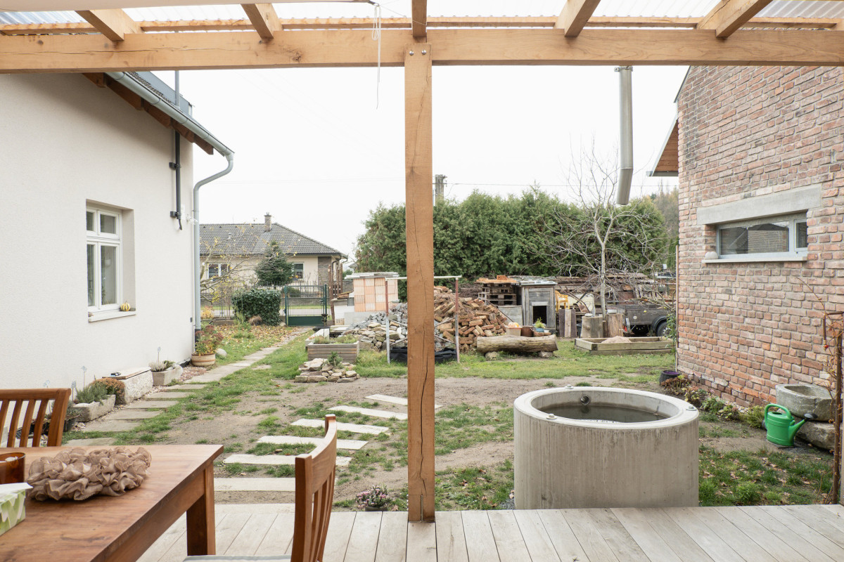 Dříve využívaný chlívek teď funguje jako technické zázemí sousedícího rodinného domu a zároveň malé wellness. (Terasa a zázemí ve stodole; tamti_architekti)