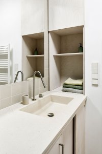 Umyvadlo v koupelně je součástí betonové desky. (Rekonstrukce bytu na Vinohradech, Markéta Bromová architekti)