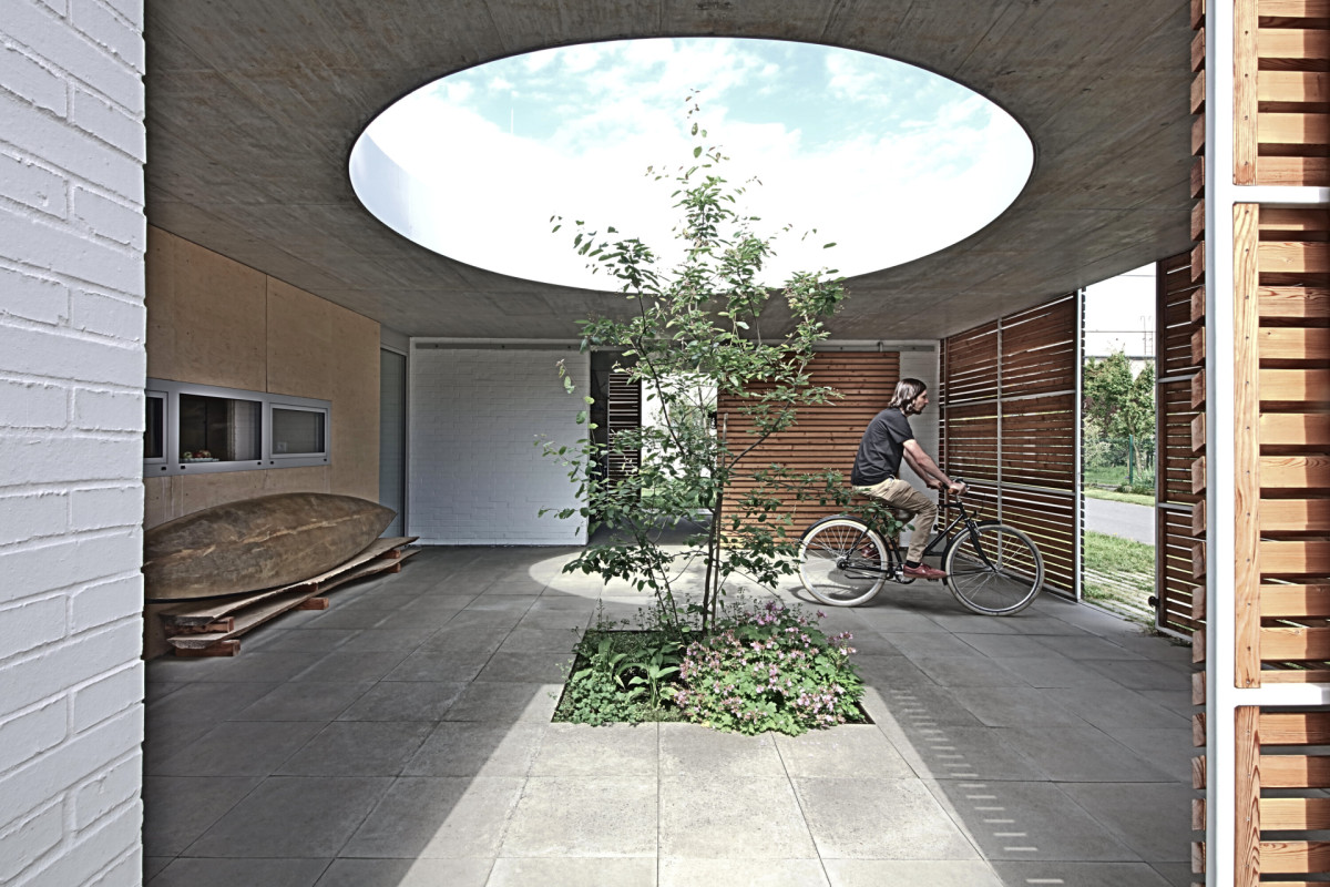 V atriu roste strom, architekti pro něj do zastřešení navrhli kruhový otvor. (Rodinný dům Polanka nad Odrou; bydloarchitekti)