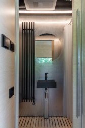 Podélně řešená kabina má ve své centrální části zabudovanou koupelnu s kuchyní