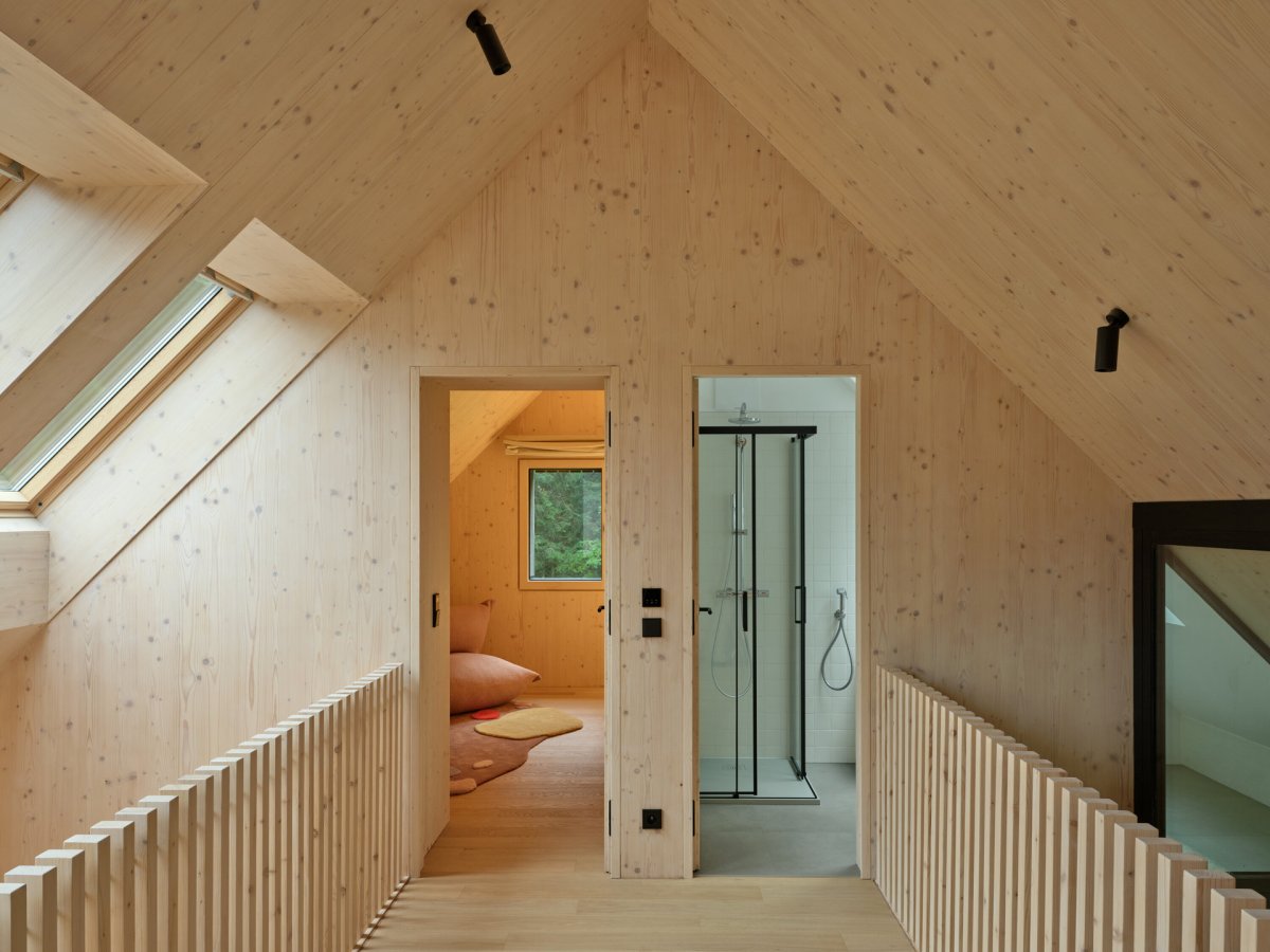 Pohled od horního patra, kde pokoje zpřístupňuje galerie. (Chalupa Na Kukačkách; edit! architects)