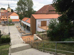 Knihovna ve Šlapanicích, Milan Podroužek a spolupracovníci: Knihovna s restaurací ve Šlapanicích stojí na okraji městského parku a hned vedle budovy gymnázia