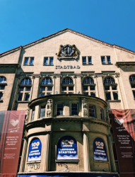 Zvenku budovy pokrývají plakáty, některá okna jsou zabedněná