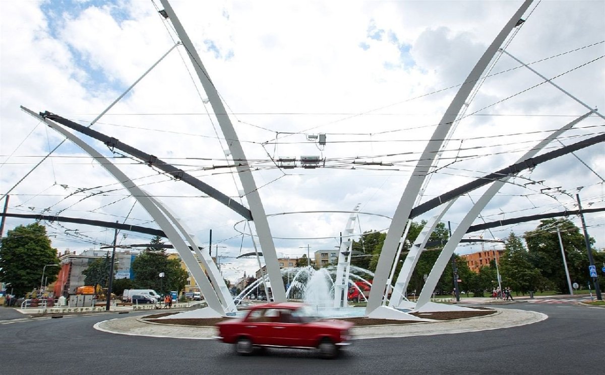 Mezi české architekty, kteří s múzami obcují nejdivočeji, patří Patrik Kotas. Jeho práci můžete znát z metra Střížkov, pražských tramvajových zastávek jako např. Hlubočepy, K Barrandovu a Geologická, ale také z Hradce Králové, kde navrhoval dopravní terminál nebo křižovatku U Koruny. Tento kruhový objezd stál 128 miliónů Kč. Uměleckou kvalitu ale radši se Zahou Hadid nesrovnávejme. / Patrik Kotas, Křižovatka U Koruny – foto