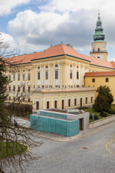 Stavba stojí v místě křížení dvou ulic, hned vedle arcibiskupského zámku a přímo v historickém centru Kroměříže. (Vstupní objekt do zámeckých sklepů s trafostanicí v Kroměříži od Atelier Štěpán)