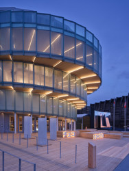 Od vchodu stoupá člověk po ochozu směrem vzhůru až do výše čtvrtého patra. „Zdánlivě nekonečný pohyb po úzké spirále je působivý. V některých místech se koridor výrazně rozšiřuje – jakoby ‚nadechne‘,“ píší Apropos Architects.