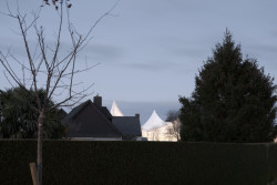 V noci bílý textilní plášť fasády svítí do dálky. (Sportovní a kulturní centrum Marie-Jose Perec a Josephine Baker v La Bouëxière ve Francii; onze04)