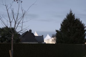 V noci bílý textilní plášť fasády svítí do dálky. (Sportovní a kulturní centrum Marie-Jose Perec a Josephine Baker v La Bouëxière ve Francii; onze04)