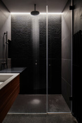  Interiér pracuje s danými principy psychologie barev a kontrastu, například kontrast světlé haly a tmavé koupelny.