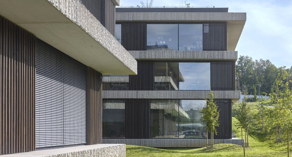 Fasáda je doplněná o dřevěné prvky a kámen. (Centrála ČSOB v souladu s přírodou; Chalupa architekti a partneři)