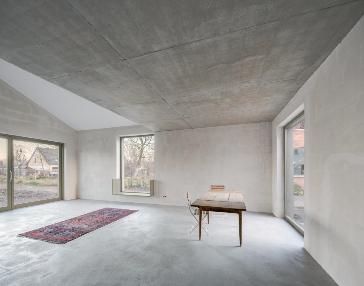Strohé interiéry zútulňuje krb nebo pastelově zelená okna. (Rodinný dům s ateliérem, Helga Blocksdorf Architektur)