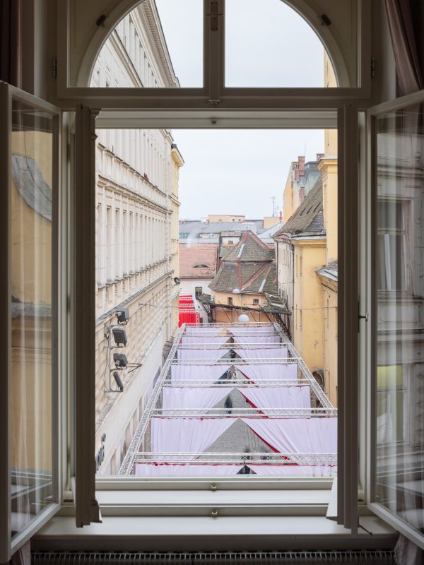 Prostor ulice je rozdělený oponami na jednotlivé sekce (Peer Collective a Kateřina Šedá, Festival vánočních zlozvyků)