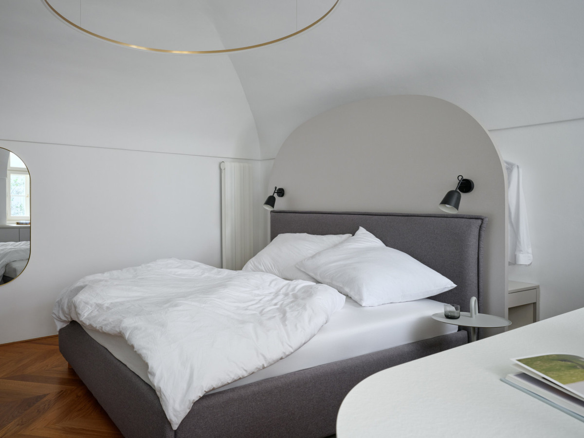 Nejnápadnější je v prostoru postel s výrazným zaobleným čelem. (Rekonstrukce miniapartmánu; ateliér Tunicate)