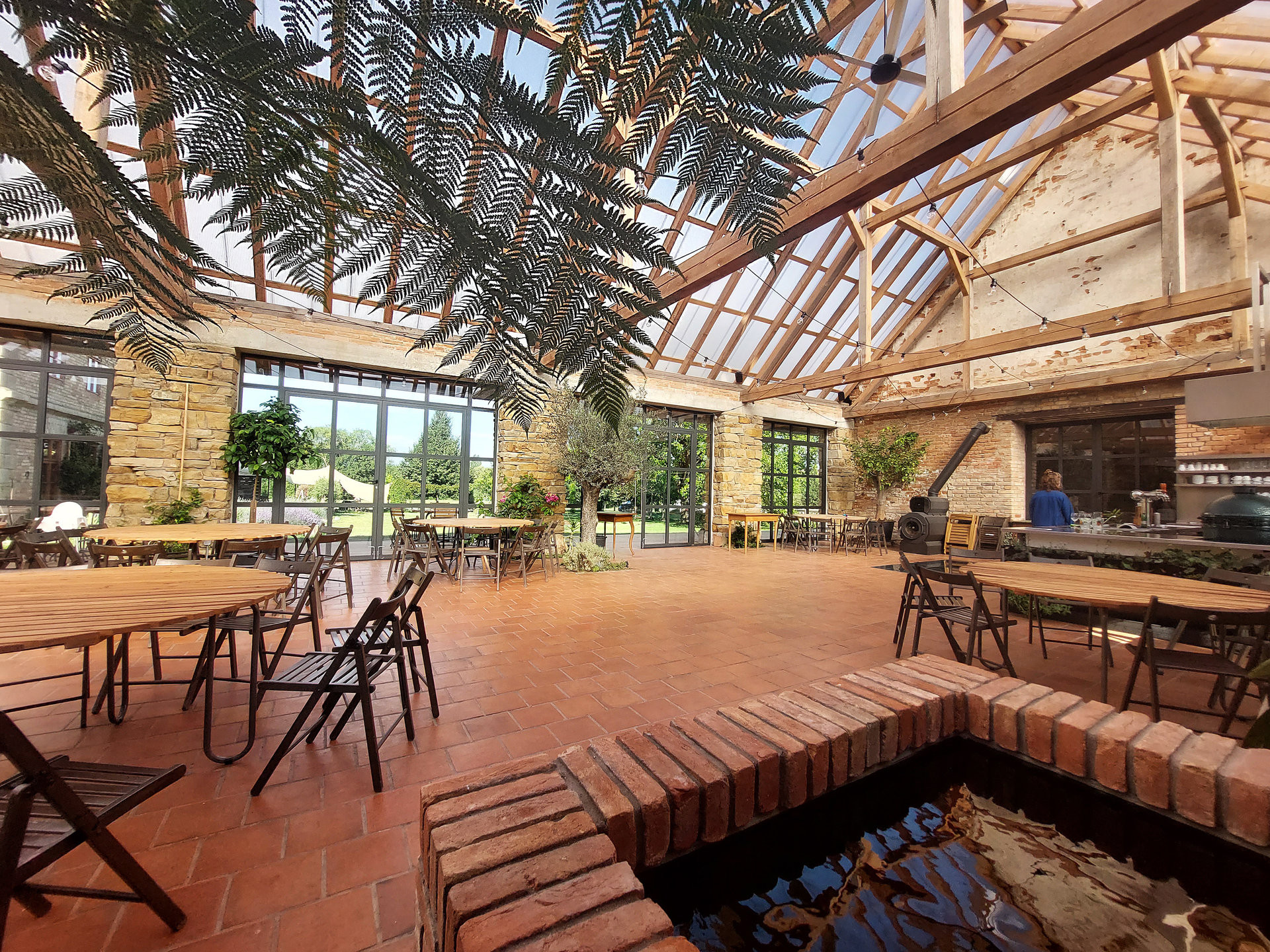 Dominantním prvkem objektu je hmota valbové střechy. Původní krov byl nahrazen tesařskou kopií a keramickou krytinu nahradil lehký polykarbonát, díky kterému je hlavní sál bohatě prosvětlen. Interiér doplňují exotické rostliny vysazené přímo do země a kašna sloužící k jejich zavlažování. Podlahu tvoří cihelná dlažba, která podtrhuje charakter prostoru.