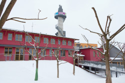 Nejvýraznějším prvkem celého areálu je nezvyklá vyhlídková věž. „Pod budovou kluboven je centrální kotelna pro všechny tři objekty s tím, že kolem komína se vine schodiště na vyhlídkovou plošinu, tak aby děti a další zájemci mohli vidět celý svůj areál z ptačí perspektivy," popsal její roli Vlado Milunić.