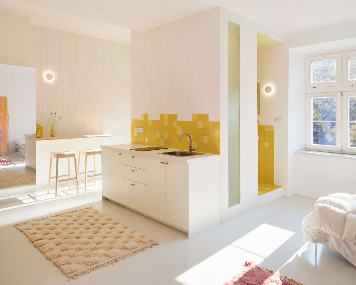 S barem sousedí drobná kuchyňská linka. (Byt pro malířku v Praze-Holešovicích od Plus One Architects)