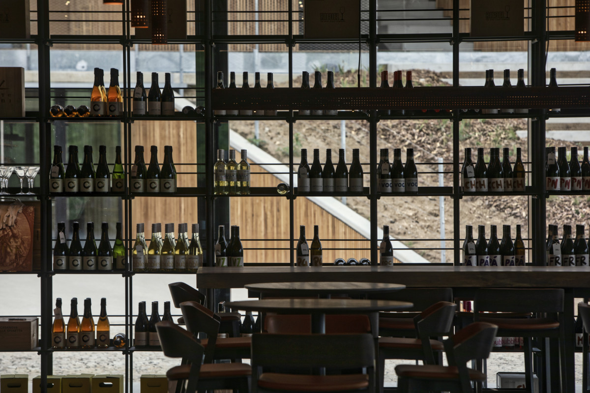Výhled ven skrze police s lahvemi ARTEVINI (ARTEVINI Resort & Winery u Velkých Pavlovic; znamení čtyř – architekti)