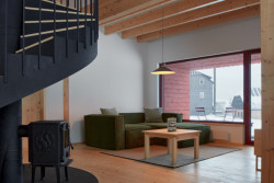 Celé přízemí je navrženo skromně. Kombinace smrkového dřeva, bílé omítky a okenních otvorů, které rámují pohledy do okolní přírody. A to naprosto stačí. (Chata Bučina v Malé Úpě, studio ADR)