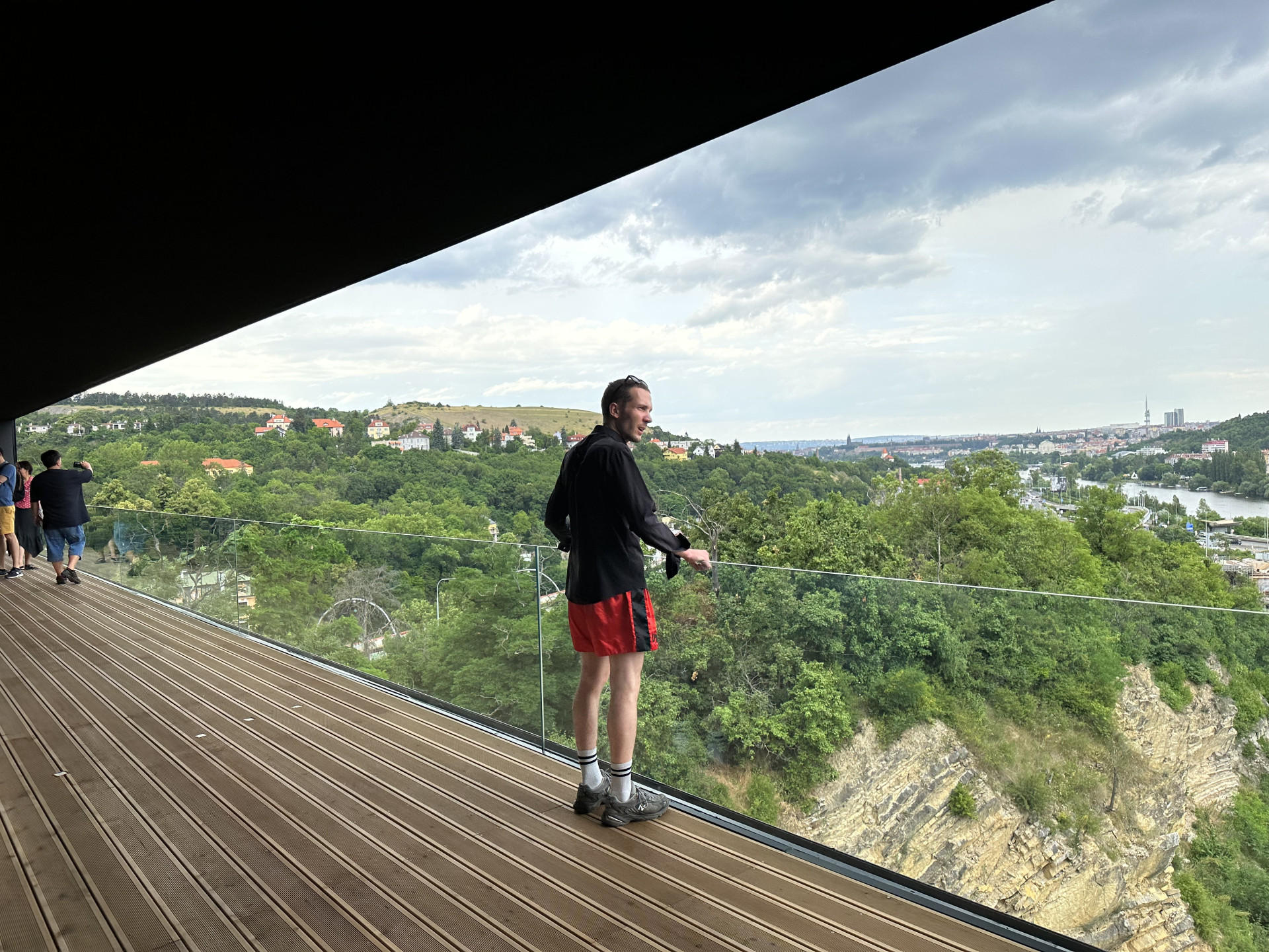 Lodžie černého domu. Výhled je tu na skály a Vltavu, ale také na Barrandovský most, po němž projede 140 tisíc aut denně. Hluk byl podle architektů  problém, řešili ho trojitým zasklením oken.