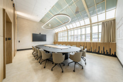 Čisté linie, velkorysý otevřený prostor bez vizuálního členění a důraz na práci s denním světlem. (Zasedací místnost Státní tiskárny cenin; JKH Architects)