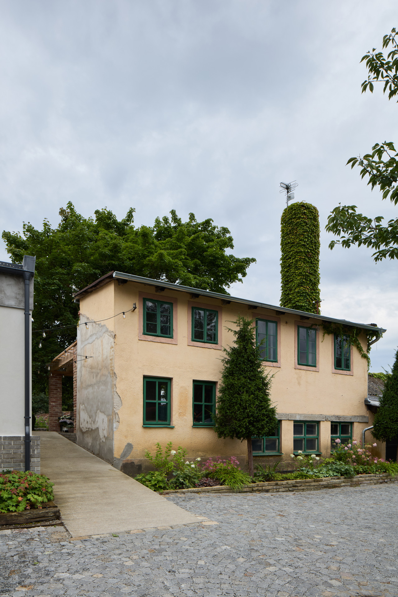 Objekt se zelenými okny se zatím postupně opravuje. (Krafferova zahrada v Jindřichově Hradci od matěj šebek architekti a Ateliér Za Mák)