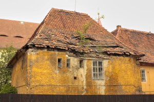 Střechami zatékalo a vlhkost poškodila většinu interiéru. (Kapucínský klášter v Žatci před obnovou)