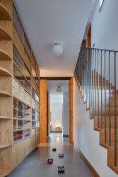 Interiéry vily v Klánovicích, KURZ architects: Tak autoři nazvali objekt, do kterého začlenili kuchyňskou linku, knihovnu i obývací stěnu, v jejímž středu visí televize.